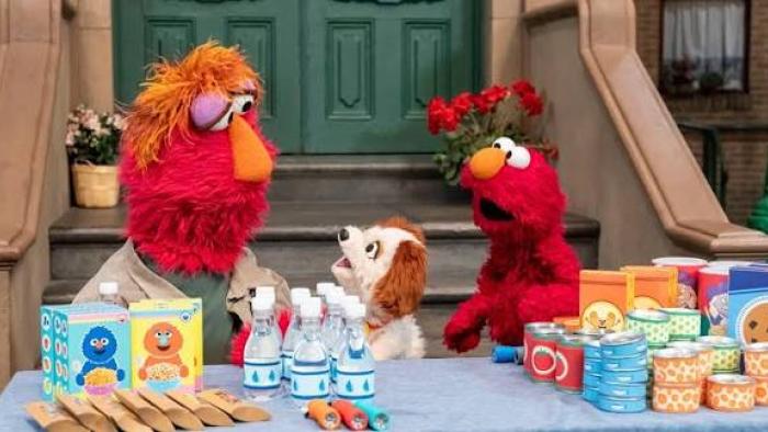 Storm On Sesame Street TV: Elmo with his Dad and dog distributing supplies like snacks and drinks outside a building.