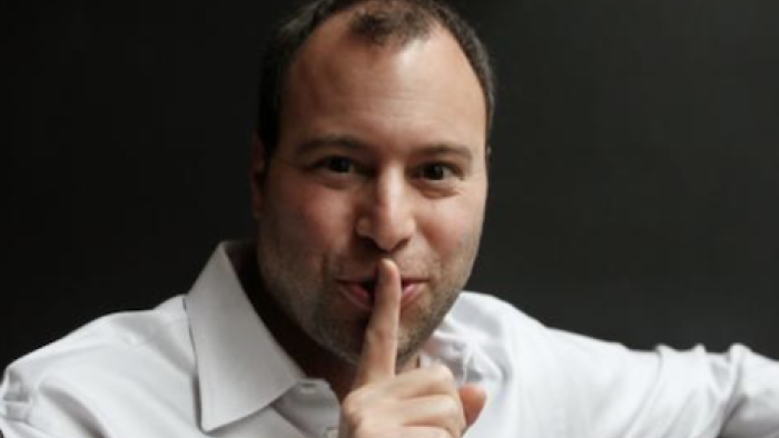 The Ashley Madison Afair screenshot 1: Noel Biderman in white shirt holds finger to lips. 