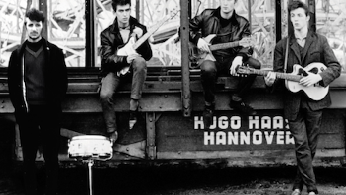 The Beatles Anthology TV show screenshot 1: Ringo Starr, George Harrison, John Lennon, and Paul McCartney standing together in Liverpool.