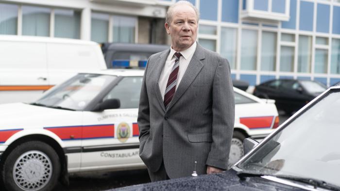 The Bombing of Pan Am 103 TV show screenshot 3: Peter Mullan stands in front of a blue car. 