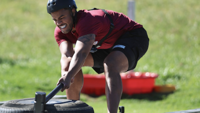 The Challenge: World Championship: An MVP in red shirt from Britain moves large tire with mallet in contest. 