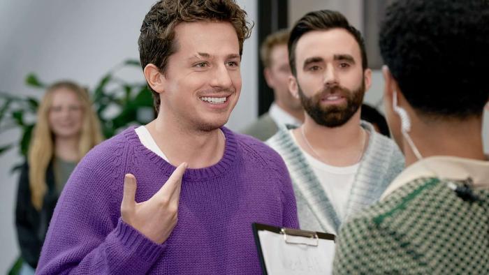 The Charlie Puth Show TV Show screenshot 2: Puth and Mike O’Donnell talk to someone with a clipboard. Charlie wears a purple sweater.