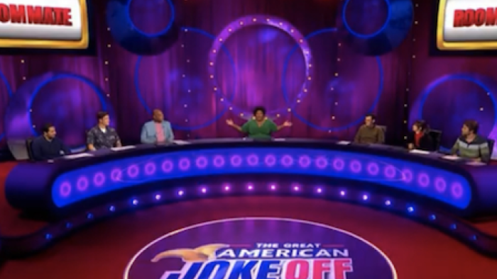 The GThe Great American Joke Off TV show screenshot 2: Comedians sit on either side of the red and blue set with Dulce Slaon in the middle. 