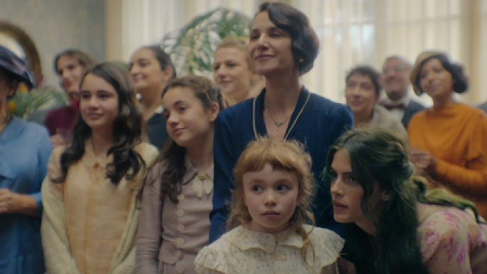 The House of the Spirits screenshot 2: The del Valle family members smiling while Rosa whispers something to Clara.