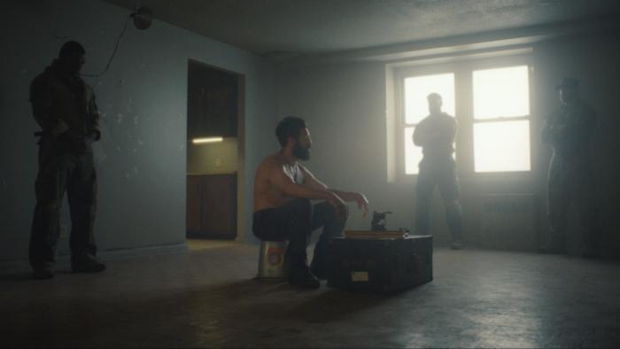 The Punisher: One Last Kill TV show screenshot 2: Jon Bernthal sits in a dimly lit room surrounded by soldiers.