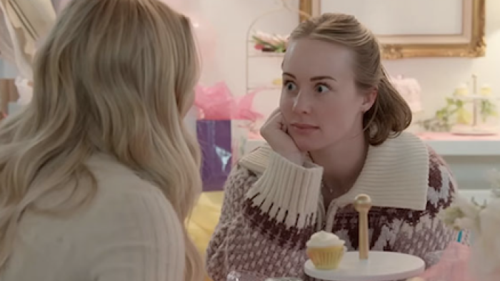 The Secret Lives of Mormon Wives screenshot 2: Two women sit at table gossiping. 