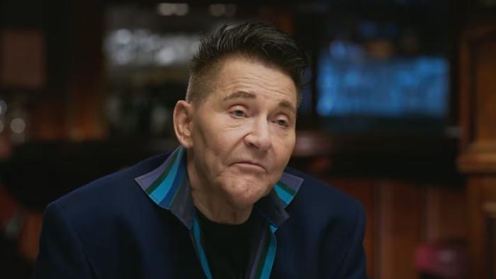 The Wonderland Massacre TV show screenshot 3: Scott Thorson sits in an interview. He wears a blue jacket.
