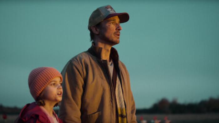The Signal TV show screenshot 1:Sven and Charlie look at something out of frame, both have dirty faces.