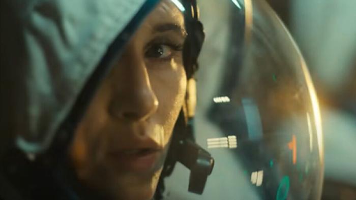 The Signal screenshot 2: Close-up shot of Paula gazing directly at camera, her face partially obscured by an astronaut helmet