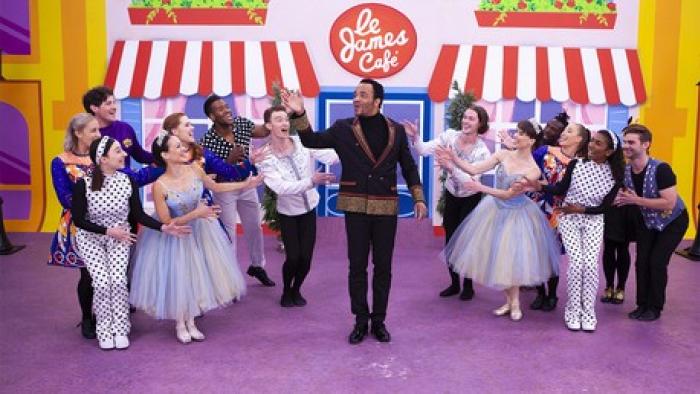The Wiggles World TV show screenshot 3: Black man dressed in extravagant clothes stand in front of crowd dressed like ballerinas.