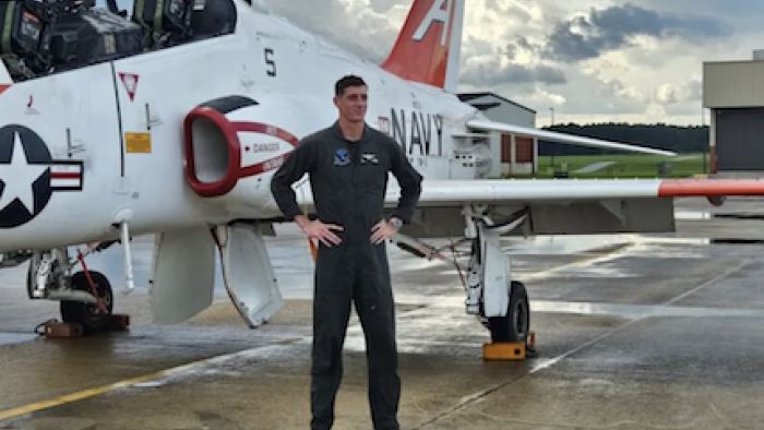 Top Guns: The Next Generation TV show screenshot 2: Austin Clagget stands in blue overalls next to fighter plane.
