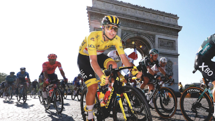 Tour de France: Unchained TV show screenshot 3: Cyclists in red, blue, and white jerseys ride by the Arch de Triomphe
