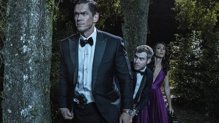 True Lies TV show: Harry stand among trees, with Luther and Maria peering behind him. 