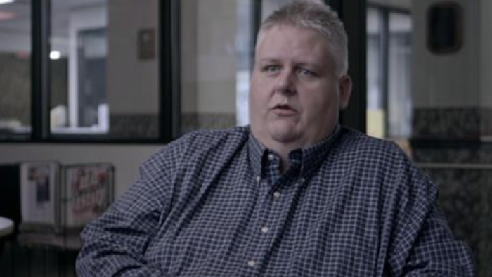 Twisted Love screenshot 3: An investigator in blue shirt discusses a case. 