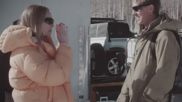 Unwell Winter Games TV show screenshot 1: Alex Cooper talks to a production staff member wearing a brown jacket..