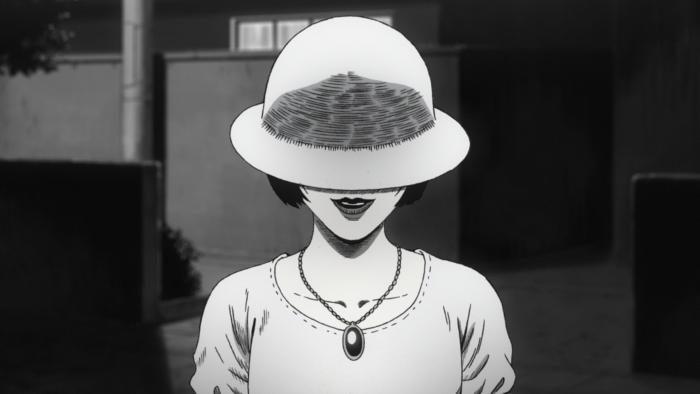 Uzumaki TV show screenshot 3: Azami faces screen. Brim of her hat obscures her face except her creepy smile.