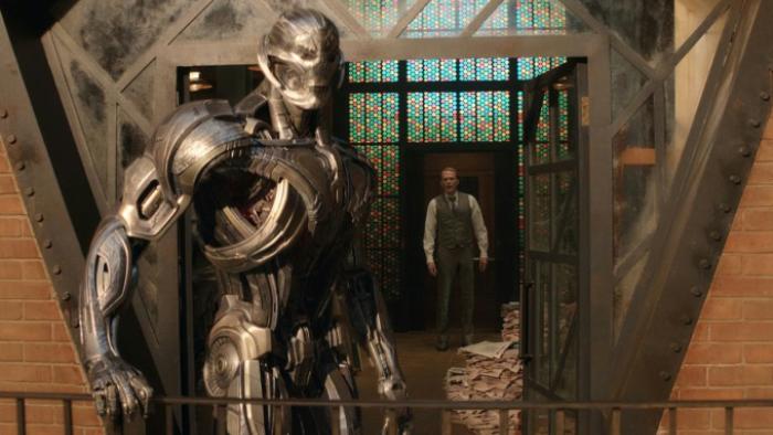 VisionQuest: Ultron, in his robotic form, looks off the balcony of his prison in Vision's mindspace as Vision, in his human avatar, stands at the door