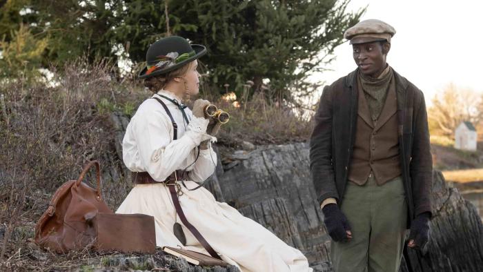 Iola Evans and Ernest Kingsley Junior. Evans wears a white dress. Junior wears green pants, a brown waistcoat, and black coat.