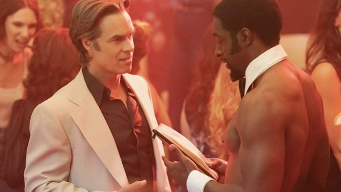 Welcome to Chippendales TV show: a clothes White man talks to a shirtless Black Chippendales dancer.