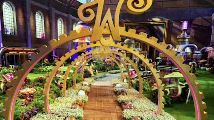 Wonka's The Golden Ticket TV show screenshot 1: Colorful whimsical candy factory interior with large decorative arches.