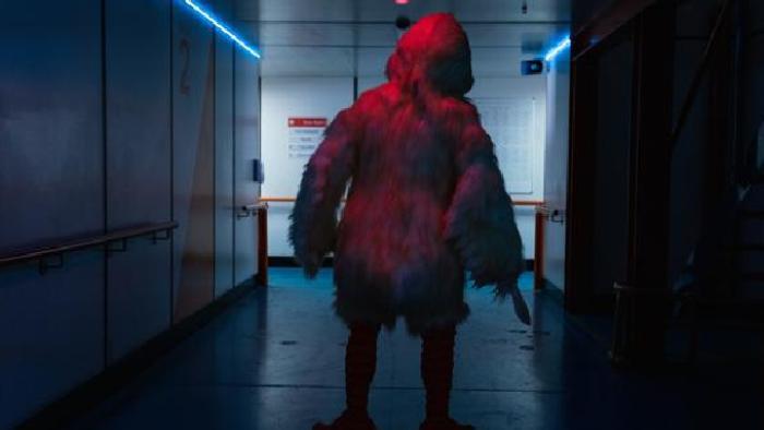 Wreck TV show: A person in a yellow duck costume stands in a darkened ship corridor; we see them from behind. 
