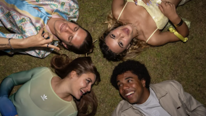 Young Millionaires TV show screenshot 1: Samia, David, Jess, and Léo lie on pavement with heads together. 