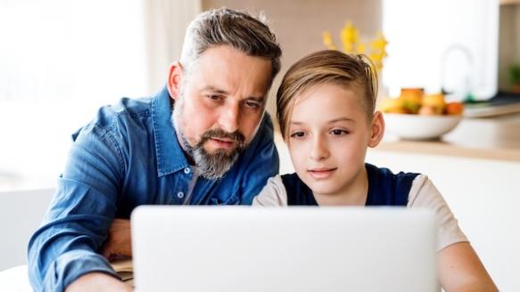 Father and son sitting at a laptop