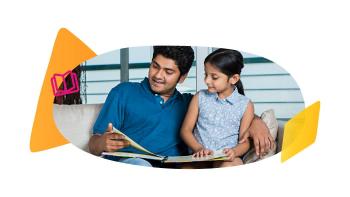 Father and daughter reading a book together on a couch.