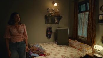 Merry Christmas: Maria stands next to a bed a dimly-lit room