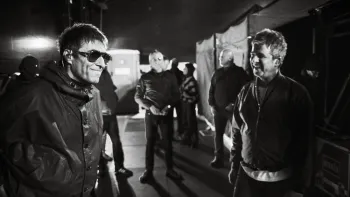 Oasis—Don't Look Back in Anger: Liam and Noel Gallagher, smiling, indoors, black and white photo