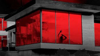 Margaux: A silhouette of a woman with her hands on the window of a modern smart house with red-lit background.