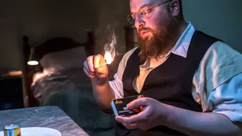 Menashe: An Orthodox Jewish man lighting a candle