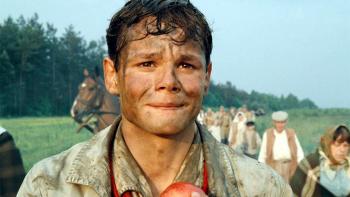 Europa Europa: Marco Hofschneider with mud on his face, looking distressed while holding an apple