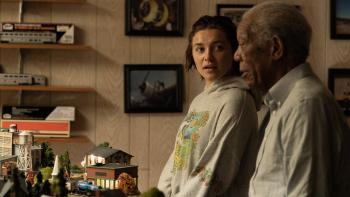 A Good Person Movie: Florence Pugh wears a sweatshirt and talks to Morgan Freeman over a model train set