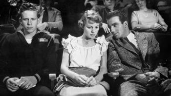 A Place in the Sun: Shelley Winters leans in to talk to Montgomery Clift in the audience of a movie theater.