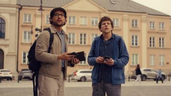 A Real Pain movie: Jesse Eisenberg stands with Will Sharpe outdoors in Warsaw