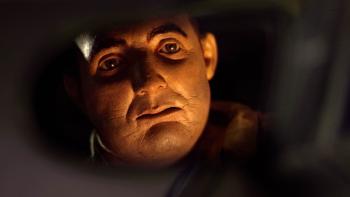 Abruptio Movie: Les Hackel (voiced by James Marsters) looks at his reflection in the rear-view mirror