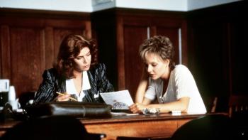 The Accused: Kelly McGillis and Jodie Foster sit in a wood-panelled room looking at a legal paper.