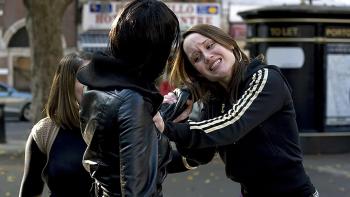 Adulthood: Two young women arguing in a street, one pulling the other's hair as another woman looks on