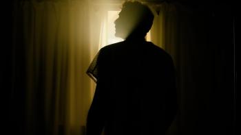 After Death Movie: A man in silhouette stands in a darkened room in front of a bright window
