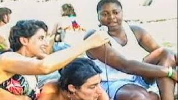 Ahead of the Curve: Women at beach talk on a microphone