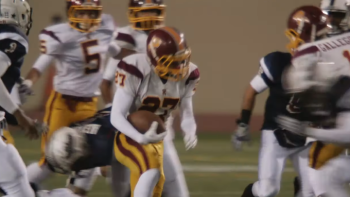 The All-Americans Movie: Scene 2 A football player holds a ball as others try to block him. 