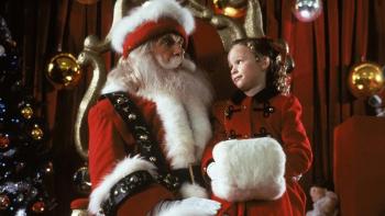 All I Want for Christmas movie: A young girl wears a red outfit as she sits on the lap of Santa