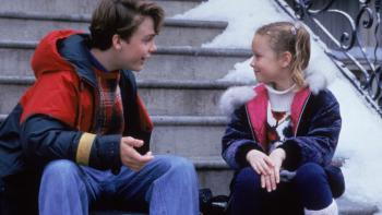 All I Want for Christmas movie: A young brother and sister smile as they talk on the steps of a New York house