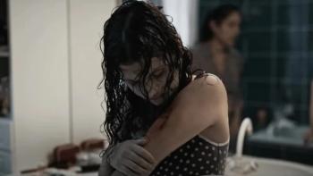 Alpha: A young teenage girl checks her arm tattoo