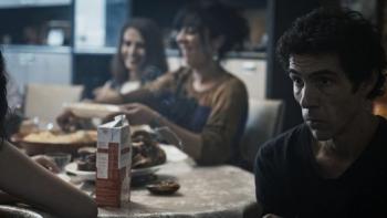 Alpha: A man looks serious while sat at a family gathering