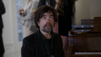 American Dreamer Movie: Peter Dinklage stands amid a group of people