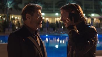 American Star Movie: Looking angry, Wilson (Ian McShane, left) faces off with Ryan (Adam Nagaitis), who holds a phone to his ear and seems to be saying something