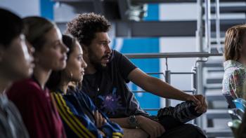 American Sweatshop Movie: Daisy, Ava, and Bob, along with other co-workers, listen to a company briefing