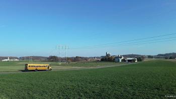 An American Pastoral movie: a school bus drives through an open field in Elizabethtown, Pennsylvania